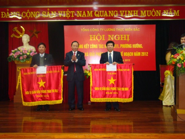 Đồng chí Nguyễn Như Lai – Chủ tịch HĐTV trao cờ Thi đua của Chính phủ cho  Lãnh đạo Công ty Bột mỳ Vinafood1 và Công ty Cổ phần Kinh doanh bao bì lương thực