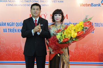 Chủ tịch HĐQT Phạm Huy Hùng trao tặng hoa chúc mừng 8/3 cho bà Nguyễn Thị Thanh Xuân, đại diện nữ CBNV VietinBank.