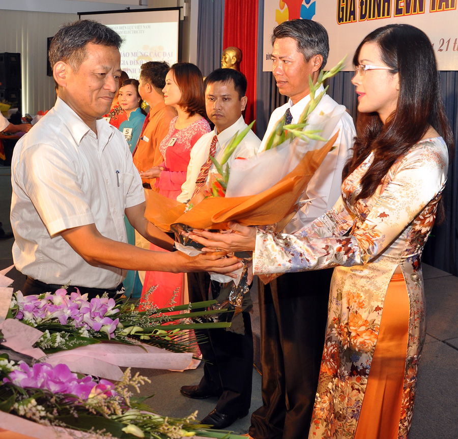Ông Nguyễn Tấn Lộc - Phó Tổng giám đốc EVN, Trưởng Ban Vì sự tiến bộ phụ nữ EVN - tặng hoa cho đại diện các gia đình tham gia Hội thi