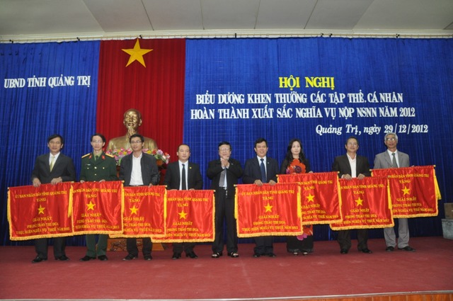 Bà Hoàng Thị Hoa - Chủ tịch kiêm Giám đốc Công ty Xăng dầu Quảng Trị nhận cờ tại buổi lễ khen thưởng DN nộp thuế xuất sắc năm 2012 do UBND tỉnh Quảng Trị tổ chức.