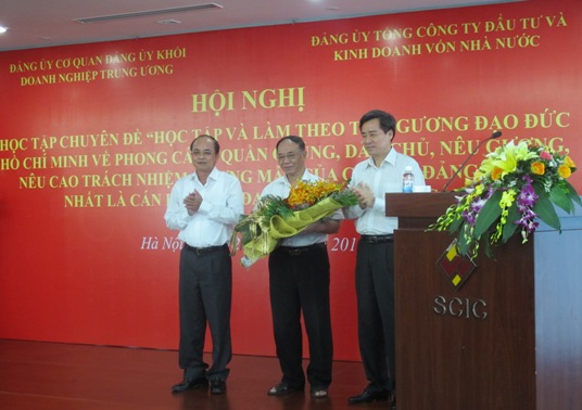 Đại diện lãnh đạo Đảng ủy cơ quan Đảng ủy Khối và SCIC tặng hoa cho GS.TS Hoàng Chí Bảo