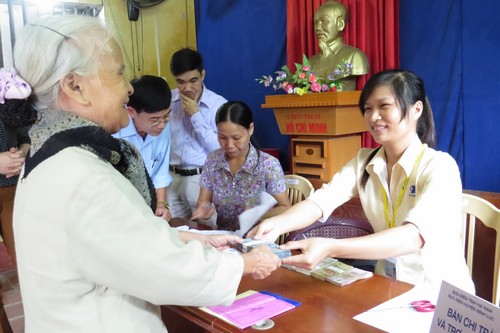Nhân viên bưu điện làm thủ tục chi trả lương hưu, trợ cấp BHXH cho người thụ hưởng tại điểm chi trả thôn Thọ - xã Mỹ Thọ - huyện Bình Lục - Hà Nam