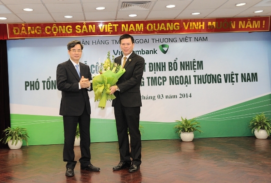 Phó Bí thư Đảng ủy Khối DNTW Nguyễn Quang Dương (bên trái) tặng hoa  chúc mừng tân Phó Tổng giám đốc Vietcombank Phạm Mạnh Thắng