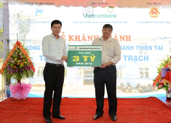 Phó Tổng giám đốc Vietcombank Phạm Mạnh Thắng (bên trái) trao tượng trưng số tiền 3 tỷ đồng cho lãnh đạo xã Quảng Trạch, huyện Quảng Xương, tỉnh Thanh Hóa