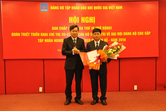 Đồng chí Nguyễn Quang Dương trao quyết định và tặng hoa đồng chí Nguyễn Xuân Sơn, tân Ủy viên Thường vụ Đảng ủy Khối DNTƯ