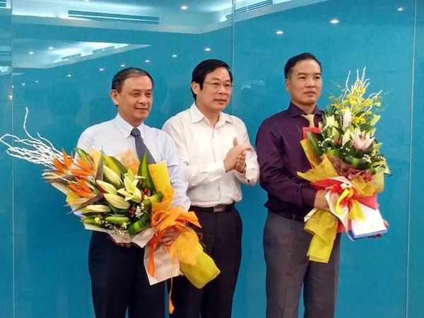 Ông Mai Văn Bình (ngoài cùng bên trái) và ông Lê Nam Trà (ngoài cùng bên phải) nhận quyết định từ Bộ trưởng Nguyễn Bắc Son 