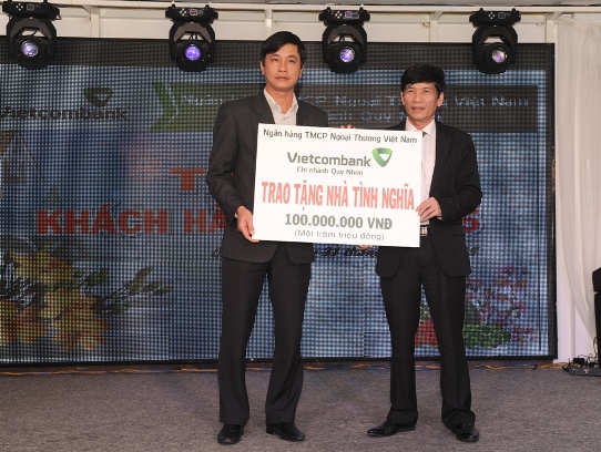 Giám đốc Vietcombank Quy Nhơn (bên phải) trao số tiền 100 triệu đồng ủng hộ xây dựng nhà tình nghĩa cho ông Huỳnh Cao Nhất, Phó Chủ tịch UBMTTQ tỉnh Bình Định