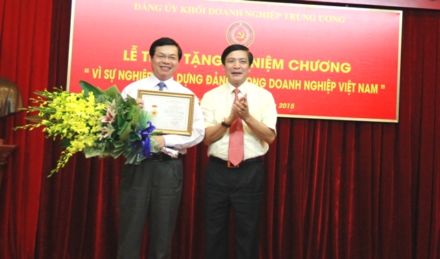 Đồng chí Bùi Văn Cường, Bí thư Đảng ủy Khối DNTW trao tặng Kỷ niệm chương cho đồng chí Bộ trưởng Bộ Công Thương Vũ Huy Hoàng.