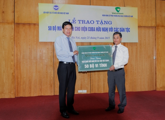 Phó Tổng giám đốc Vietcombank Phạm Mạnh Thắng trao biển tượng trưng số lượng 50 máy vi tính cho ông Đôn Tuấn Phong – Phó Chủ tịch kiêm Tổng thư ký Liên hiệp các tổ chức Hữu nghị Việt Nam