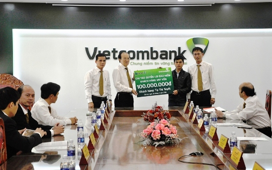 Ông Trần Văn Tiết – Phó Giám đốc Vietcombank Gia Lai (thứ 2 từ trái sang) trao trả quyền lợi bảo hiểm cho ông Lê Hợp (con trai khách hàng)