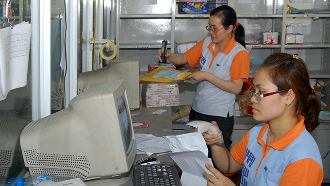 Nhân viên Công ty cổ phần chuyển phát nhanh Bưu điện (Tổng công ty Bưu điện Việt Nam) nhập mã bưu kiện, bưu phẩm. Ảnh: ANH ÐỨC