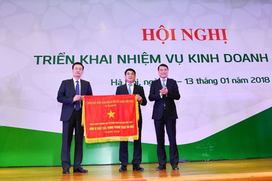 Đồng chí Lê Minh Hưng - Ủy viên BCH TW Đảng, Bí thư Ban Cán sự Đảng, Thống đốc NHNN VN (bên phải) thừa ủy quyền của Thủ tướng Chính phủ trao Cờ thi đua cho Vietcombank – Đơn vị xuất sắc trong phong trào thi đua