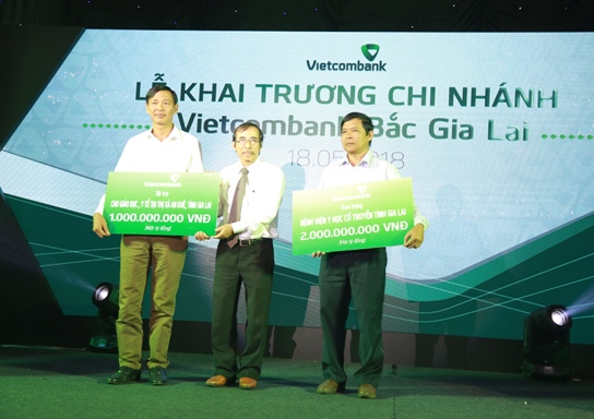 Ông Đào Hảo – Phó Tổng Giám đốc Vietcombank (giữa) trao tượng trưng số tiền tài trợ ASXH của Vietcombank cho đại diện thị trấn An Khê và Bệnh viện Y học cổ truyền Gia Lai