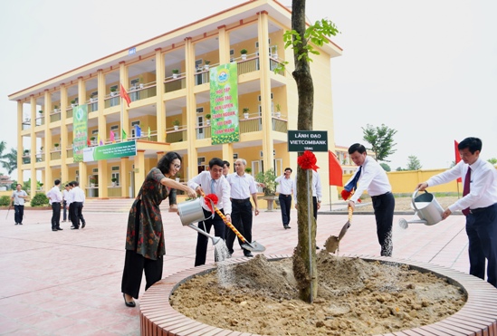 Đại diện lãnh đạo Vietcombank, Bảo hiểm xã hội Việt Nam và địa phương trồng cây lưu niệm tại sân trường