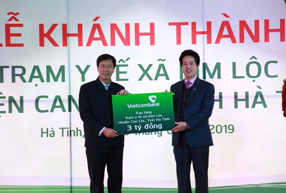 Đại diện Vietcombank trao biển tượng trưng số tiền 3 tỷ đồng tài trợ của Vietcombank để xây dựng Trạm Y tế xã Kim Lộc cho đại diện lãnh đạo địa phương