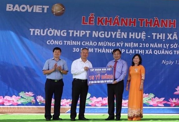 Đại diện lãnh đạo Tập đoàn Bảo Việt trao tiền hỗ trợ cho trường