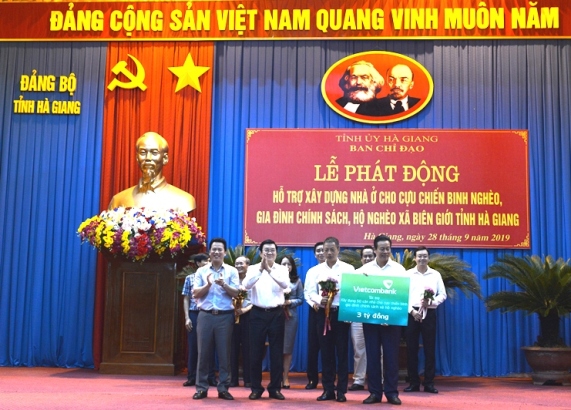 Đại diện Vietcombank trao biển tượng trưng 3 tỷ đồng hỗ trợ xây dựng 50 căn nhà cho cựu chiến binh, gia đình chính sách và hộ nghèo tỉnh Hà Giang