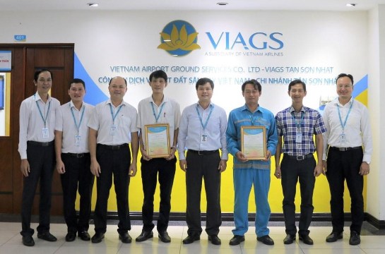 Anh Đường Khánh Tùng (thứ tư từ trái sang) và anh Trần Ngọc Kỳ (thứ ba từ phải sang) nhận thư biểu dương của Ban lãnh đạo Công ty Dịch vụ mặt đất sân bay Việt Nam. 