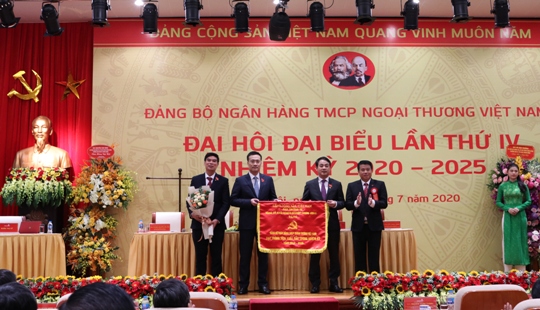 Đồng chí Y Thanh Hà Niê Kđăm - Bí thư Đảng ủy Khối DNTW trao Cờ thi đua cho Đảng bộ Ngân hàng TMCP Ngoại thương Việt Nam.
