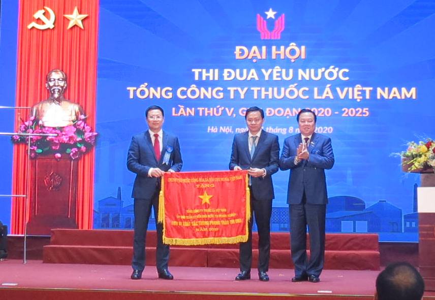 Đồng chí Nguyễn Hoàng Anh - Chủ tịch Ủy ban Quản lý vốn nhà nước tại doanh nghiệp trao cờ Thi đua của Chính phủ cho Tổng công ty Thuốc lá Việt Nam.