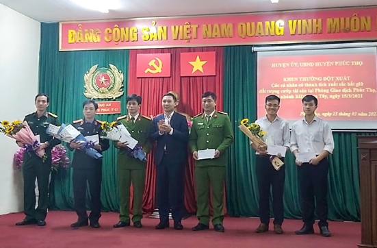 Đại diện lãnh đạo BIDV Sơn Tây tặng hoa và phần thưởng cho lực lượng công an, bộ đội và bảo vệ  đã tham gia bắt đối tượng cướp ngân hàng.