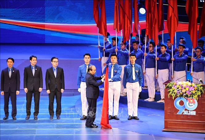 Thủ tướng Nguyễn Xuân Phúc, Chủ tịch Hội đồng Thi đua-Khen thưởng Trung ương gắn Huân chương Hồ Chí Minh lên lá cờ truyền thống của Trung ương Đoàn Thanh niên Cộng sản Hồ Chí Minh. 