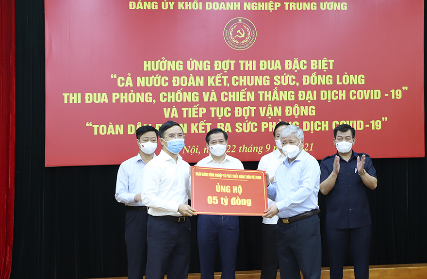 Đồng chí Phạm Đức Ấn - Chủ tịch Hội đồng thành viên Agribank (bên trái) trao biển tượng trưng số tiền 5 tỷ đồng ủng hộ công tác phòng, chống dịch Covid-19 cho  Ủy ban Trung ương MTTQ Việt Nam.