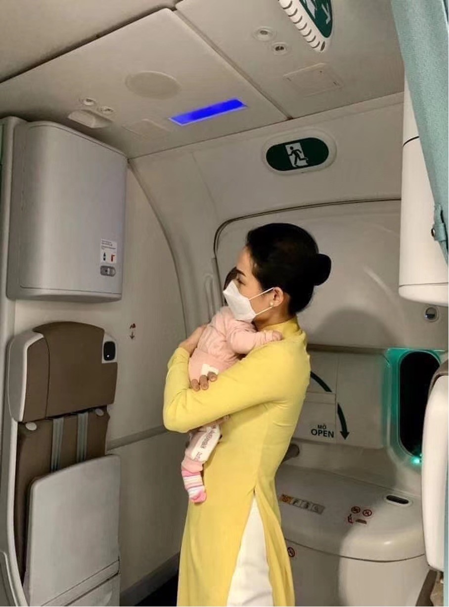 Hình ảnh tiếp viên ẵm em bé trên một chuyến bay giải cứu công dân. 