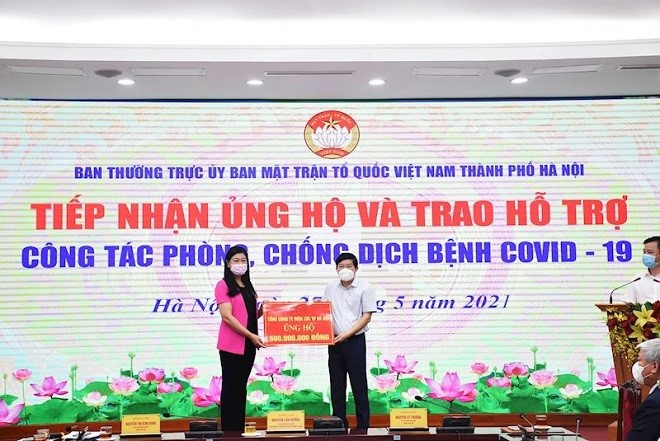 Đồng chí Nguyễn Danh Duyên – Tổng Giám đốc  EVNHANOI (bên phải) trao tiền ủng hộ công tác phòng, chống dịch Covid-19 cho TP. Hà Nội.