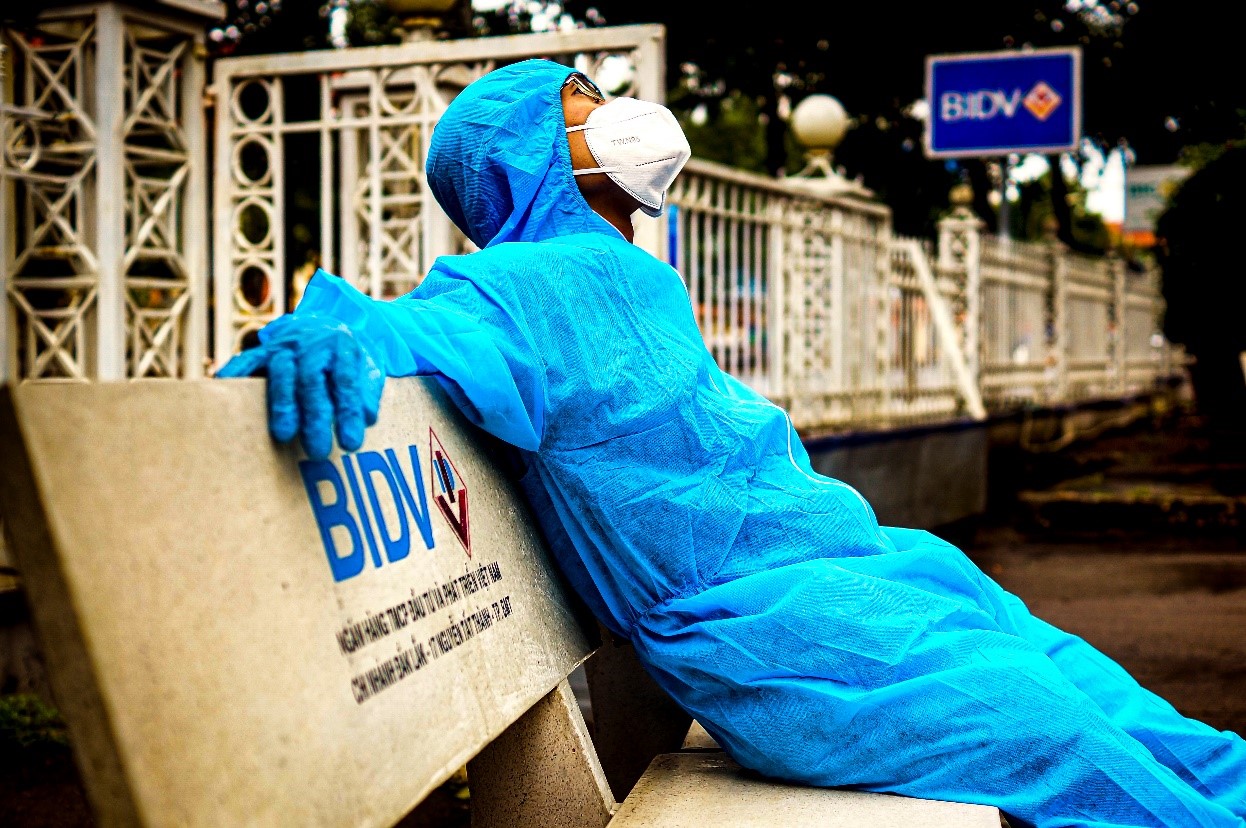 Khoảnh khắc người cán bộ BIDV CN Đăk Lăk trong bộ đồ bảo hộ kín bưng nghỉ xã hơi sau khi hoàn thành công việc tại điểm giao dịch trong vùng dịch. Dù nguy cơ lây nhiễm dịch bệnh cao, người cán bộ BIDV vẫn nỗ lực hết mình cho công việc. 