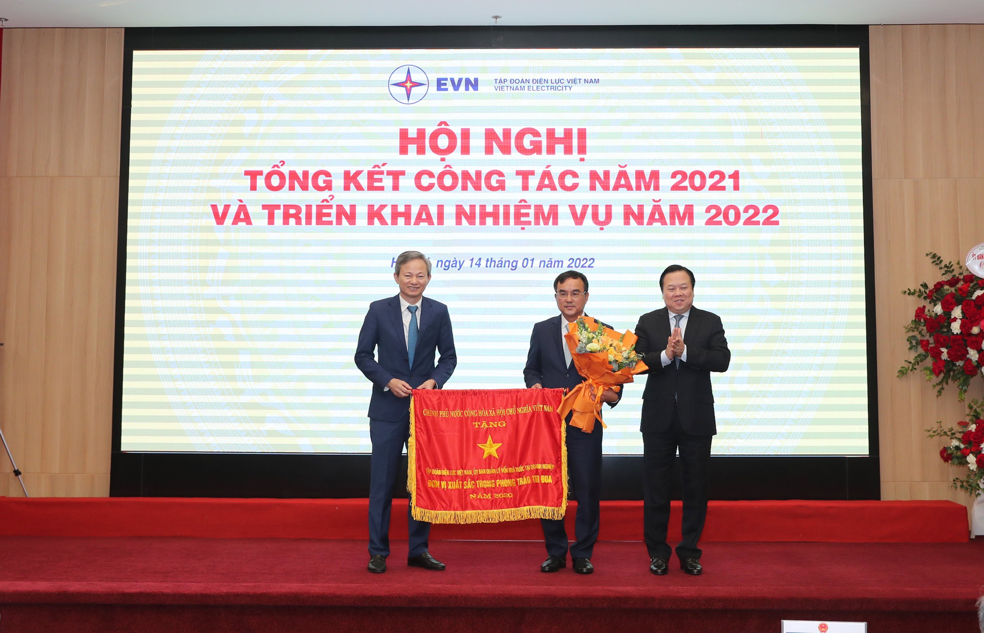 Chủ tịch Ủy ban Quản lý vốn Nhà nước tại doanh nghiệp Nguyễn Hoàng Anh trao cờ thi đua của Chính phủ cho EVN - đơn vị xuất sắc trong phong trào thi đua năm 2020 . 