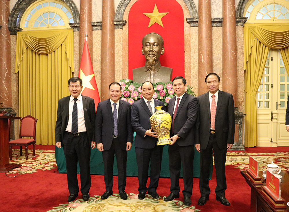 Chủ tịch nước Nguyễn Xuân Phúc thay mặt cán bộ, nhân viên Văn phòng Chủ tịch nước đón nhận quà lưu niệm của Đảng uỷ Khối Doanh nghiệp Trung ương.
