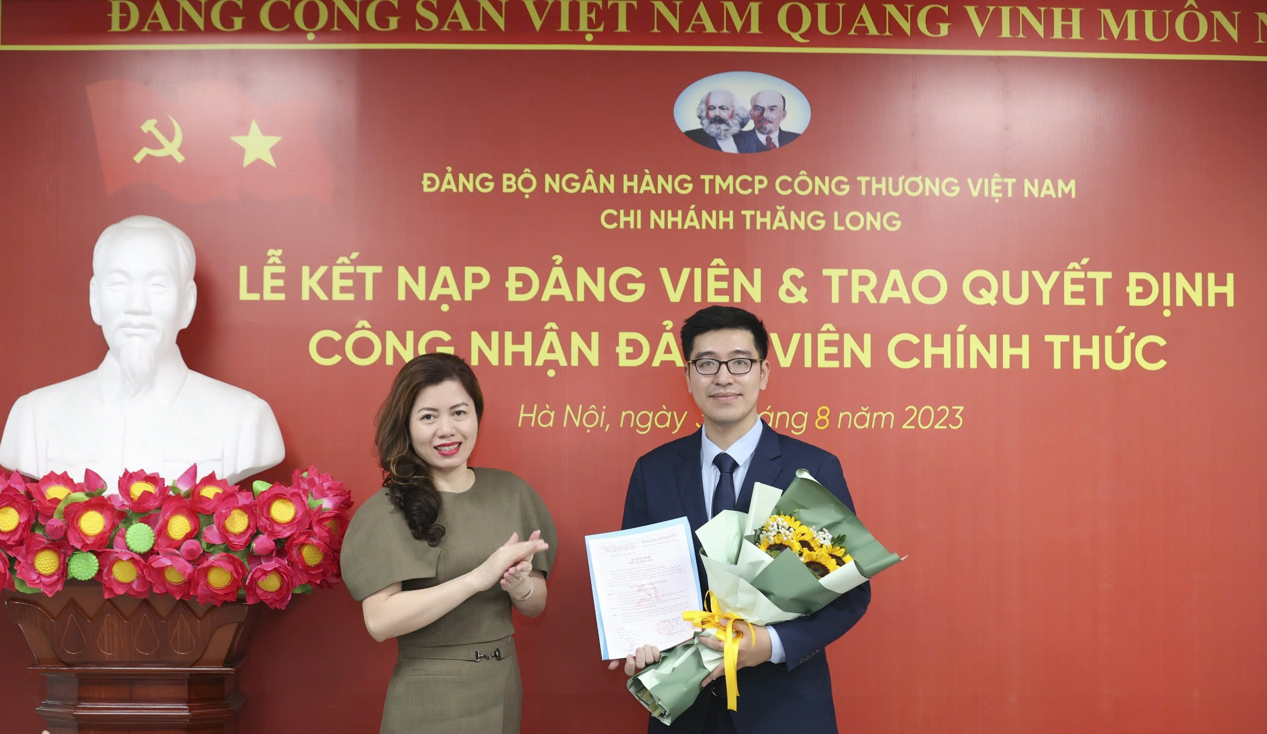 Đồng chí Bí thư Đảng uỷ VietinBank Thăng Long tặng hoa chúc mừng đảng viên mới kết nạp.